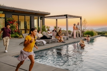 Successful family spending time next to infinity pool at sunset